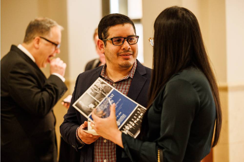 Jose Velasquez Garrido (middle) talking with an attendee